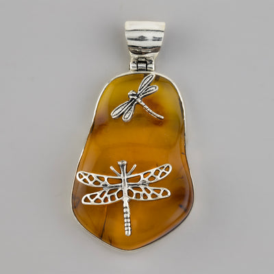large amber pendant with dragonflies