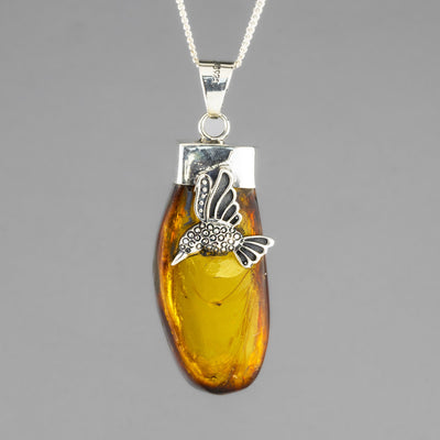 large amber pendant with a hummingbird