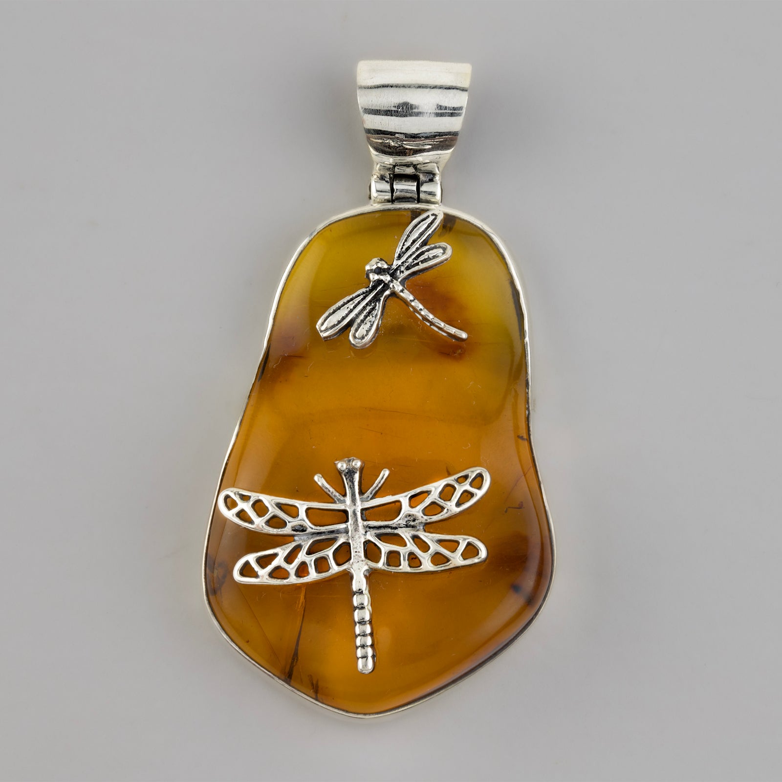 large amber pendant with dragonflies
